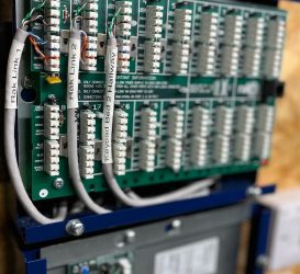 Close-up of a wired control panel featuring labeled connections for keypad and system links, demonstrating meticulous organisation and integration of electronic components.